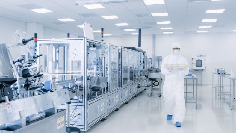 Cleanroom technician in protective suit inside pharmaceutical manufacturing facility